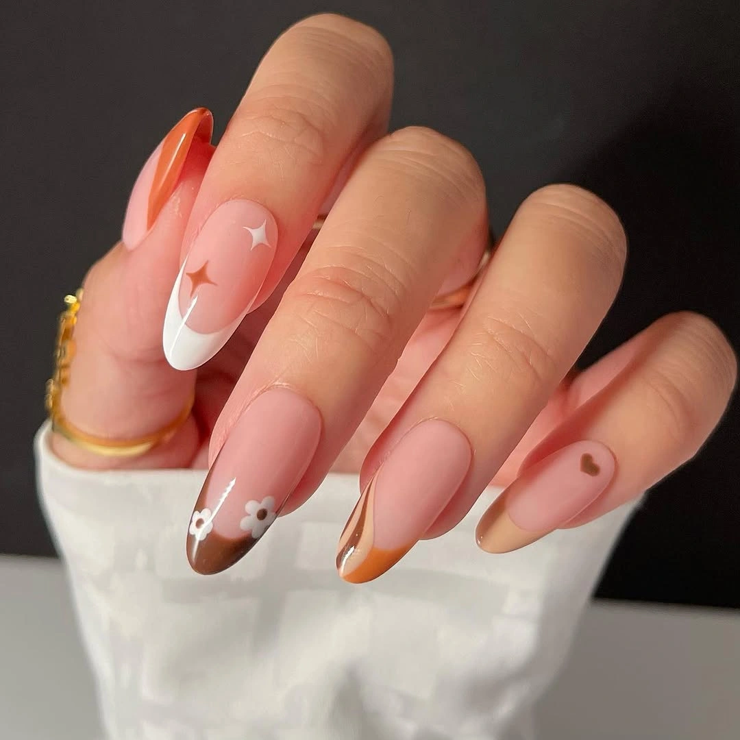 Peach almond nails with burnt orange French tips and star detail