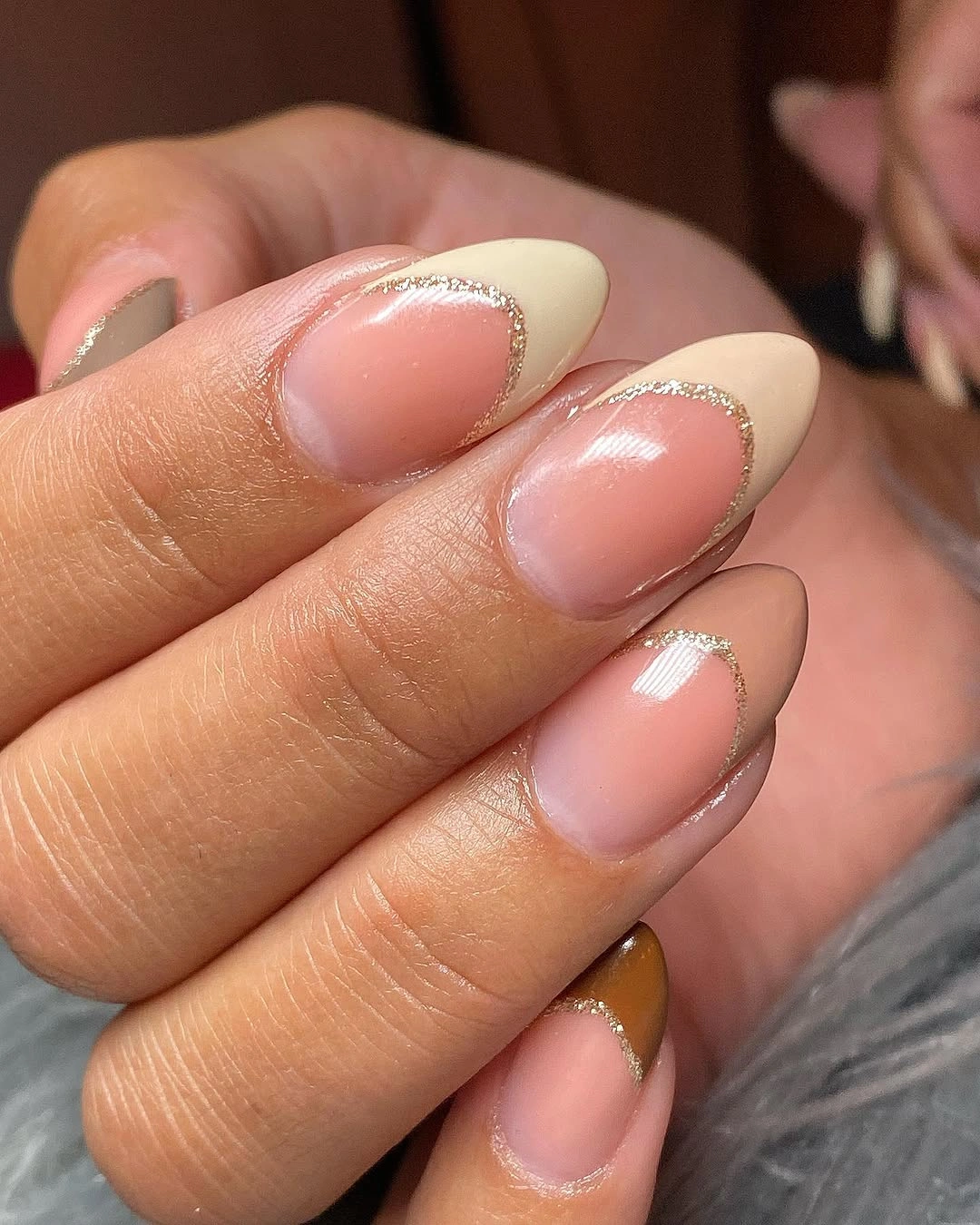 Milky almond nails with fine metallic gold French borders