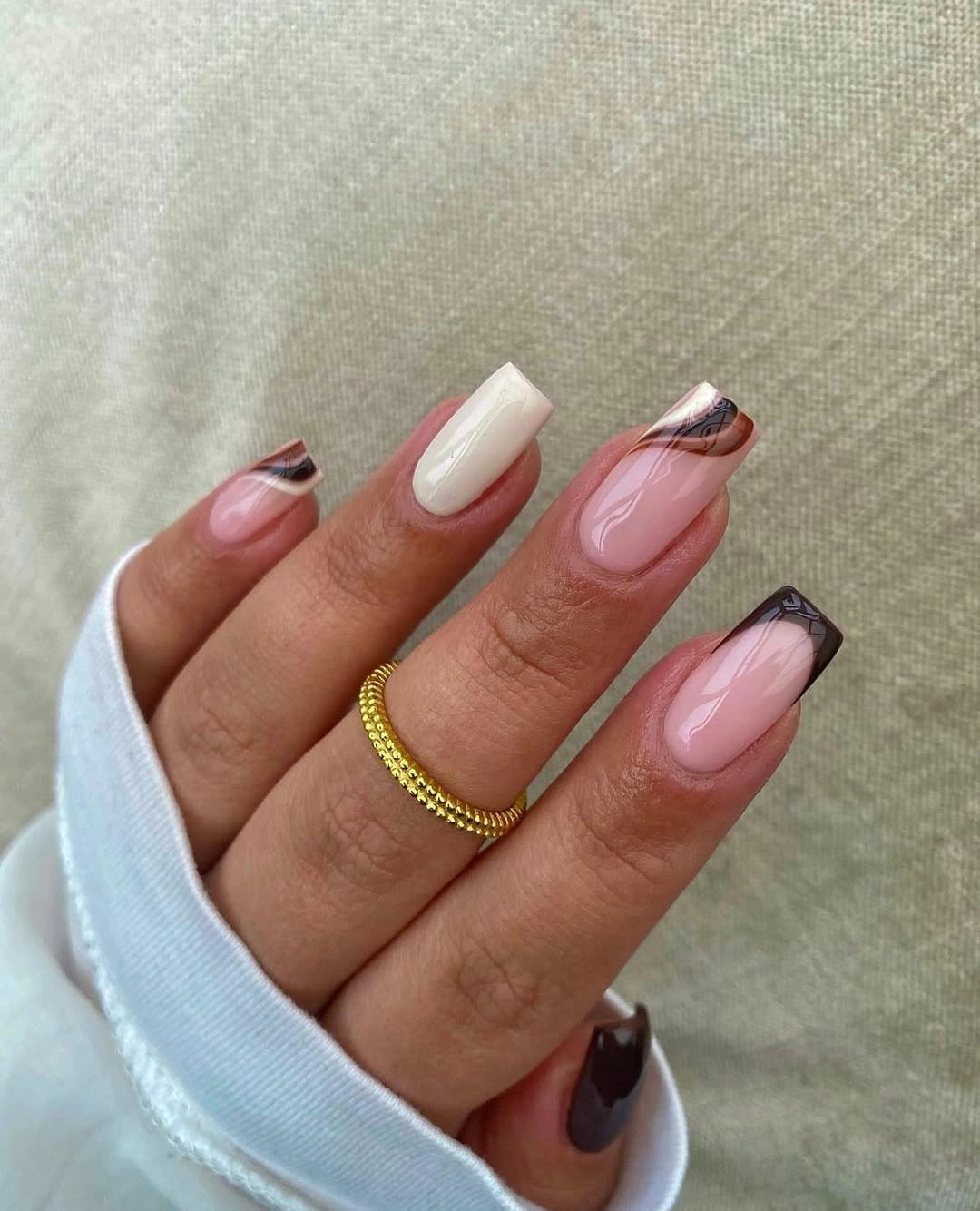 Nude pink square nails with black and white curved tips
