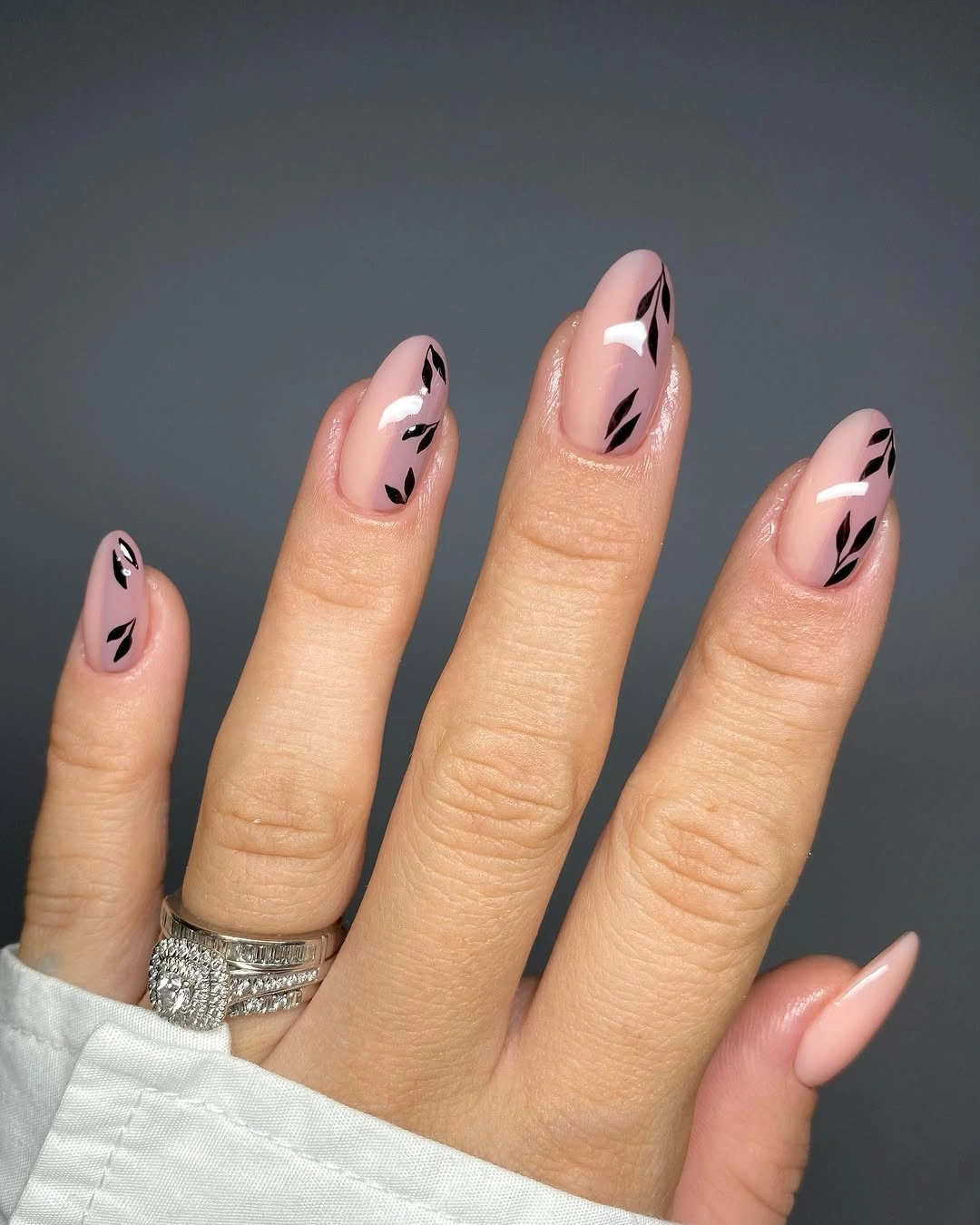 Sheer pink almond nails with black and white abstract swooshes