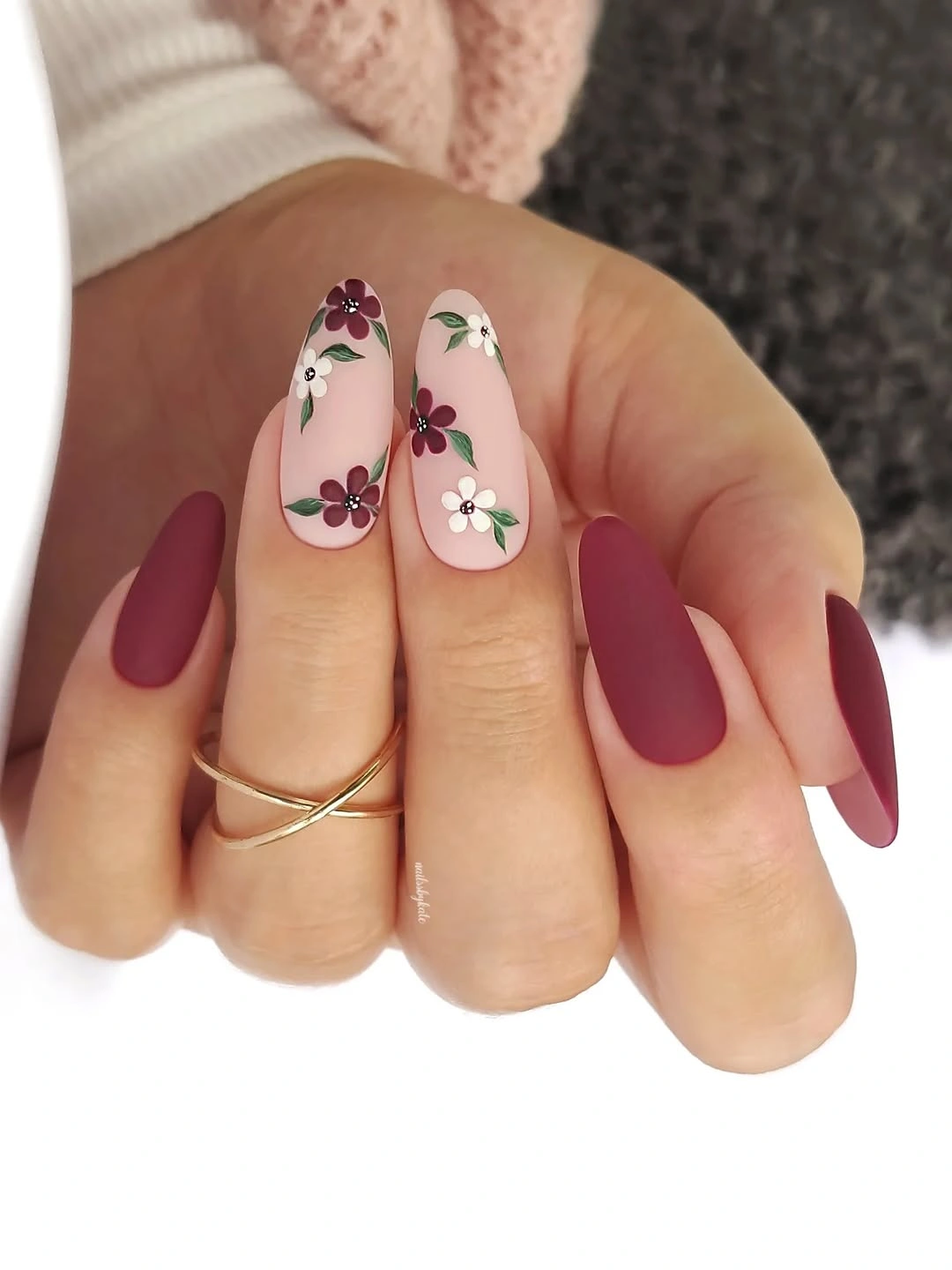 Matte burgundy almond nails with pale floral accents