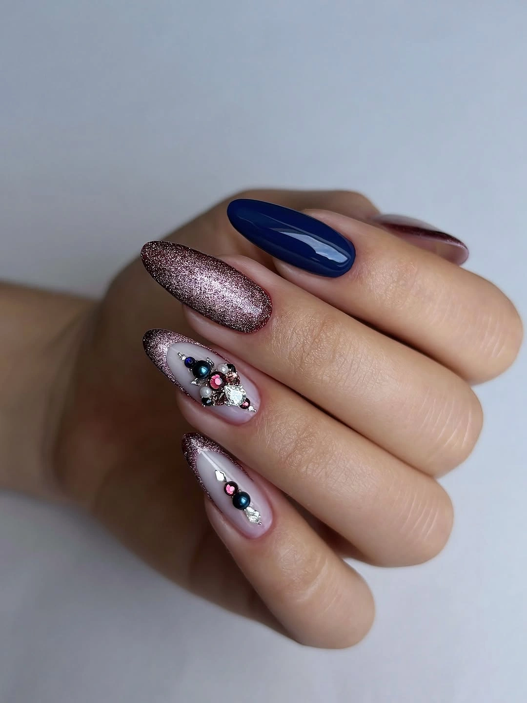 Long almond nails with navy rose glitter and jeweled accents