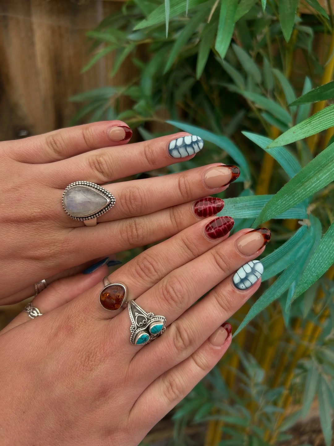 Short square nails with pale blue and red plaid-like accents