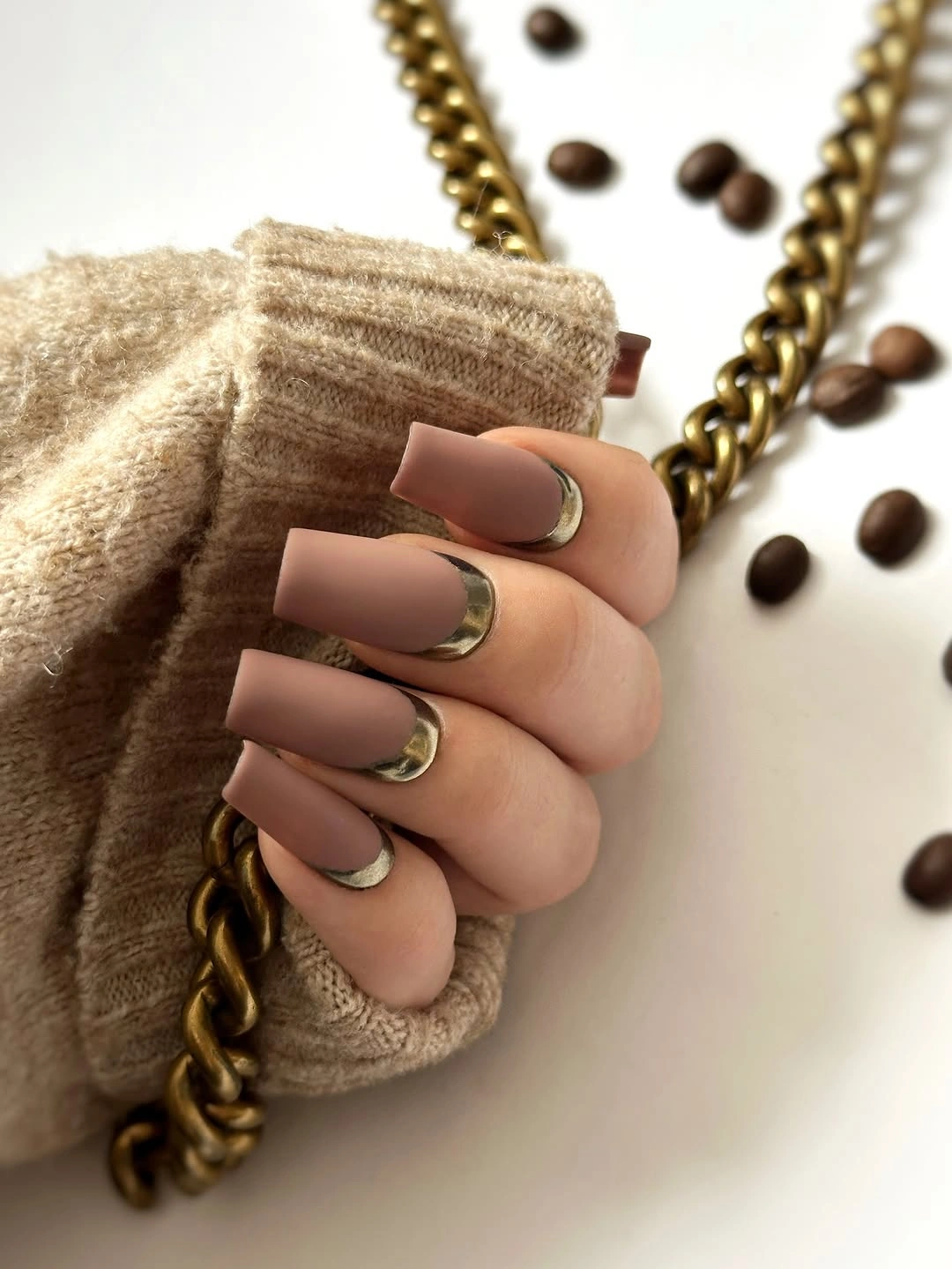 Warm neutral square nails with slim gold curved French details