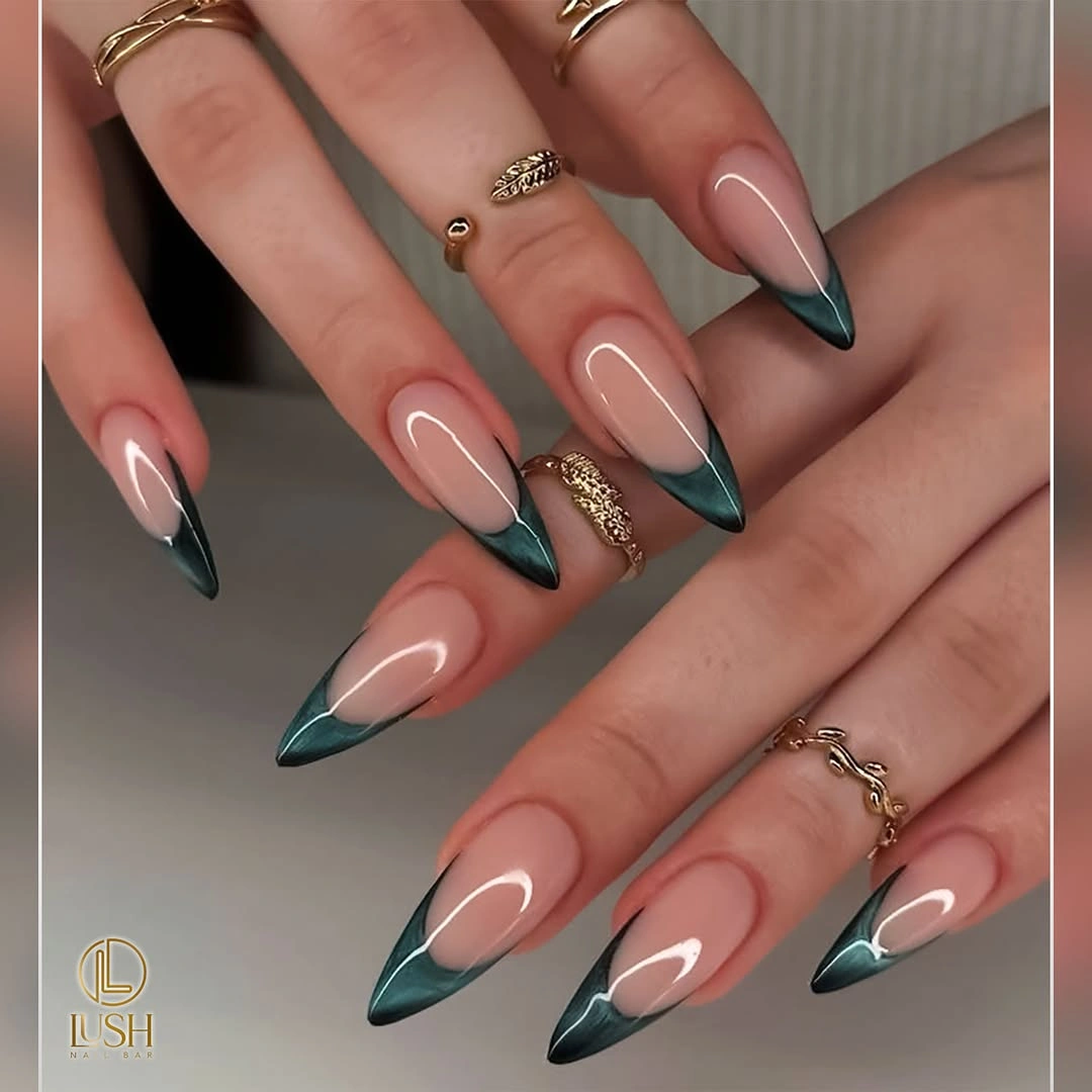 Long almond nails with deep green French tips and gold details