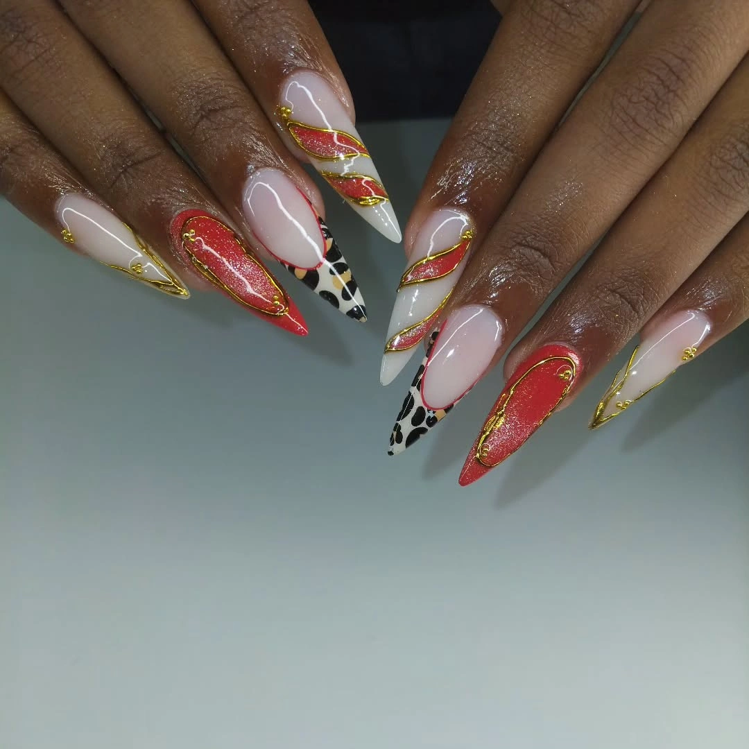 Long pointed nude nails with red orange green lines and spotted accent