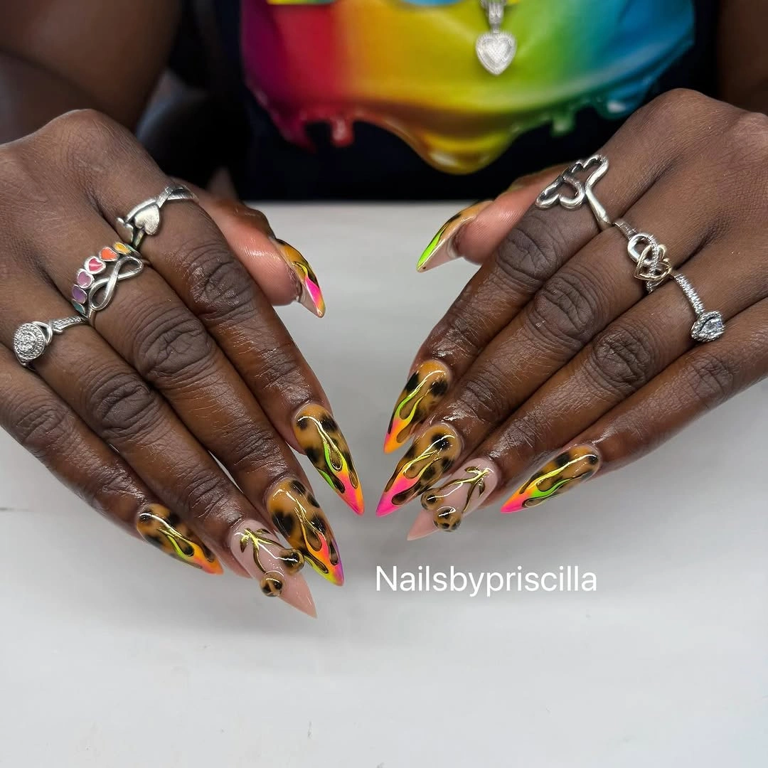Long dark pointed nails with vivid yellow orange pink and green accents