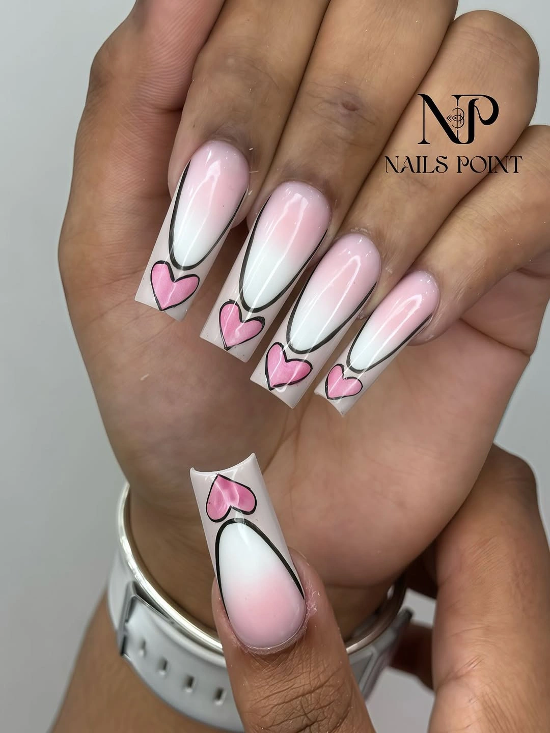 Extra long pale pink nails with layered heart tip designs