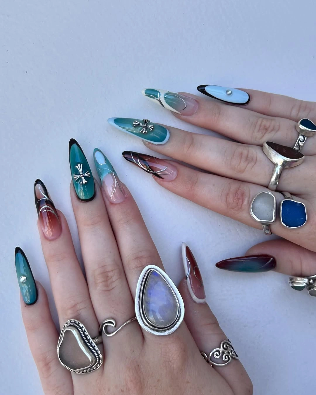 Long almond nails in teal blue plum and reflective silver jewel tones