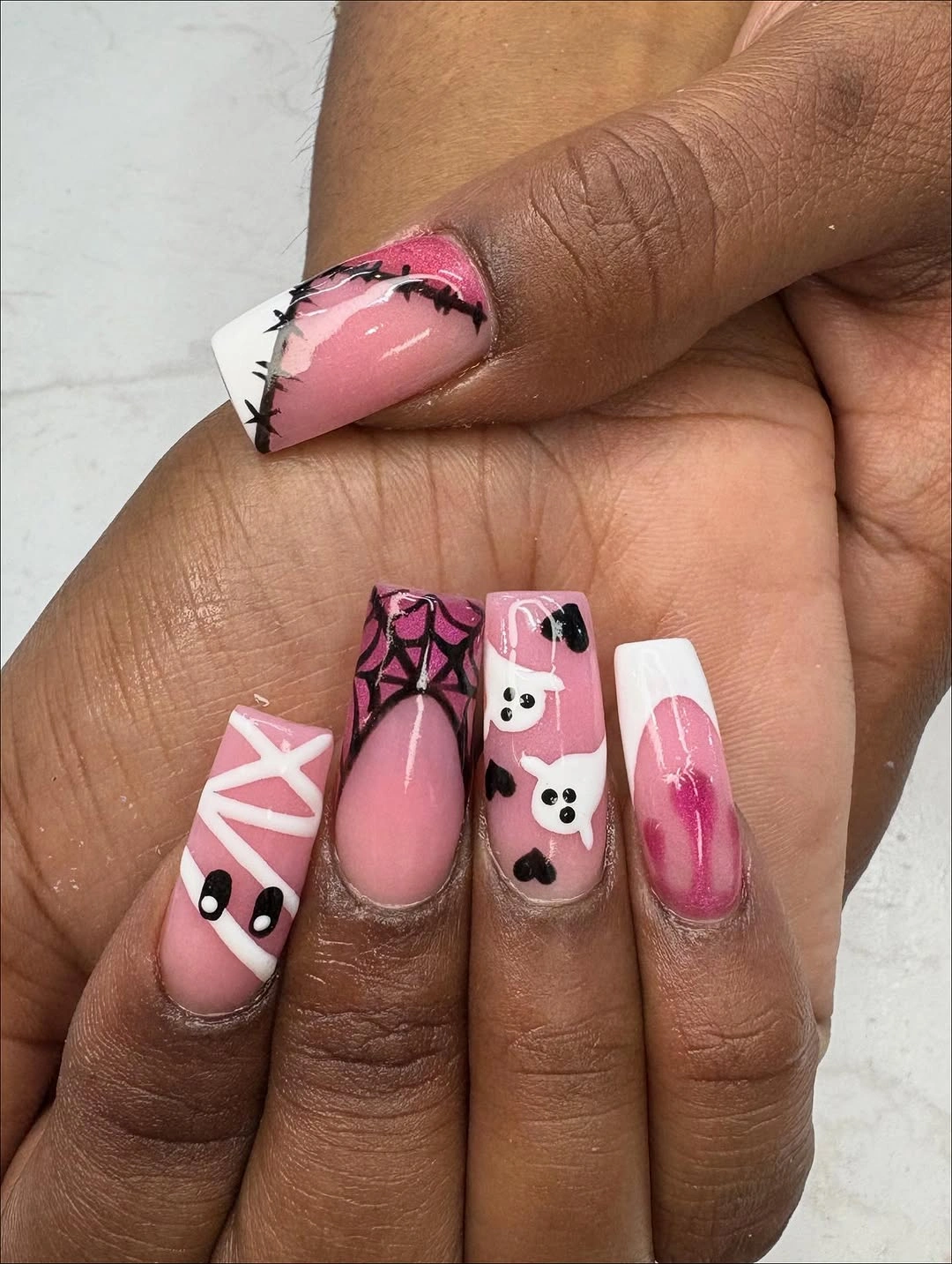 Pink nails with mixed black white checker and illustrated graphic details