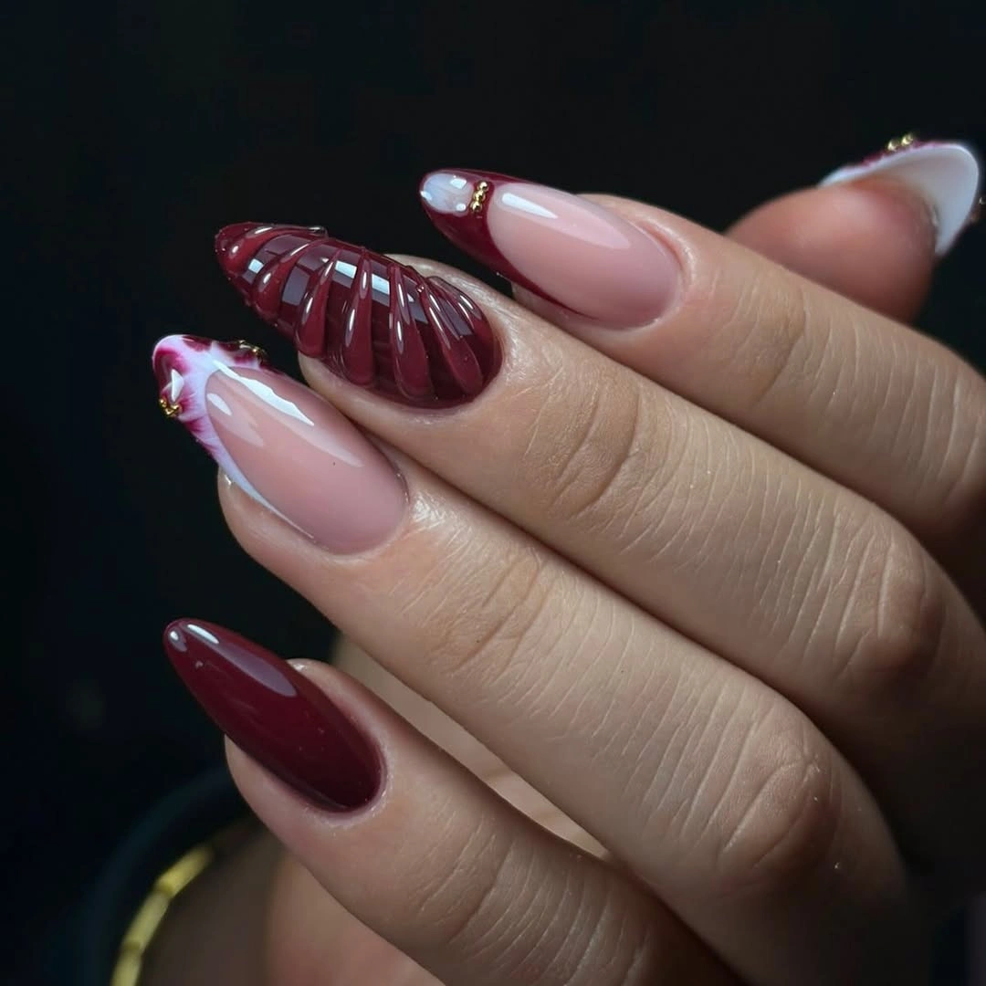 Burgundy blush almond nails with glitter and a darker textured accent