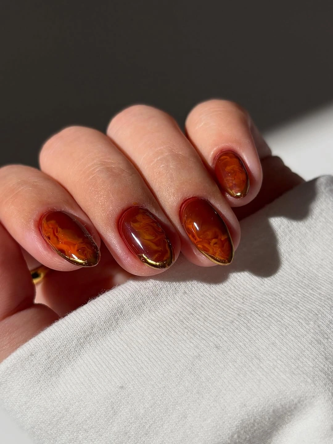 Medium almond nails in warm amber brown with dark edges