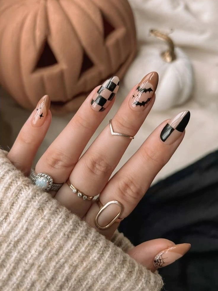 Long nude almond nails with dark graphic tips and plaid accents