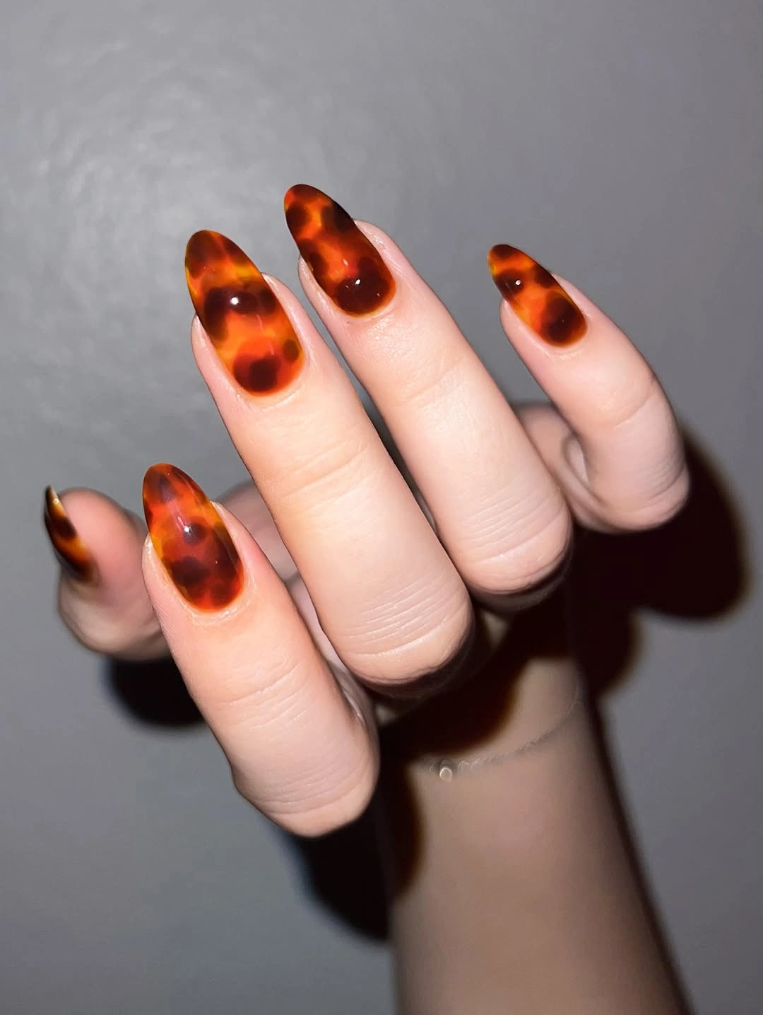 Sheer almond nails with translucent amber tortoiseshell tips