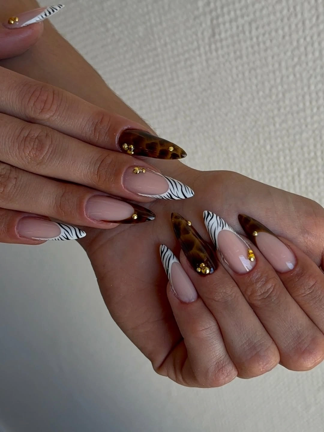 Milky pink almond nails with brown tips and white contour lines