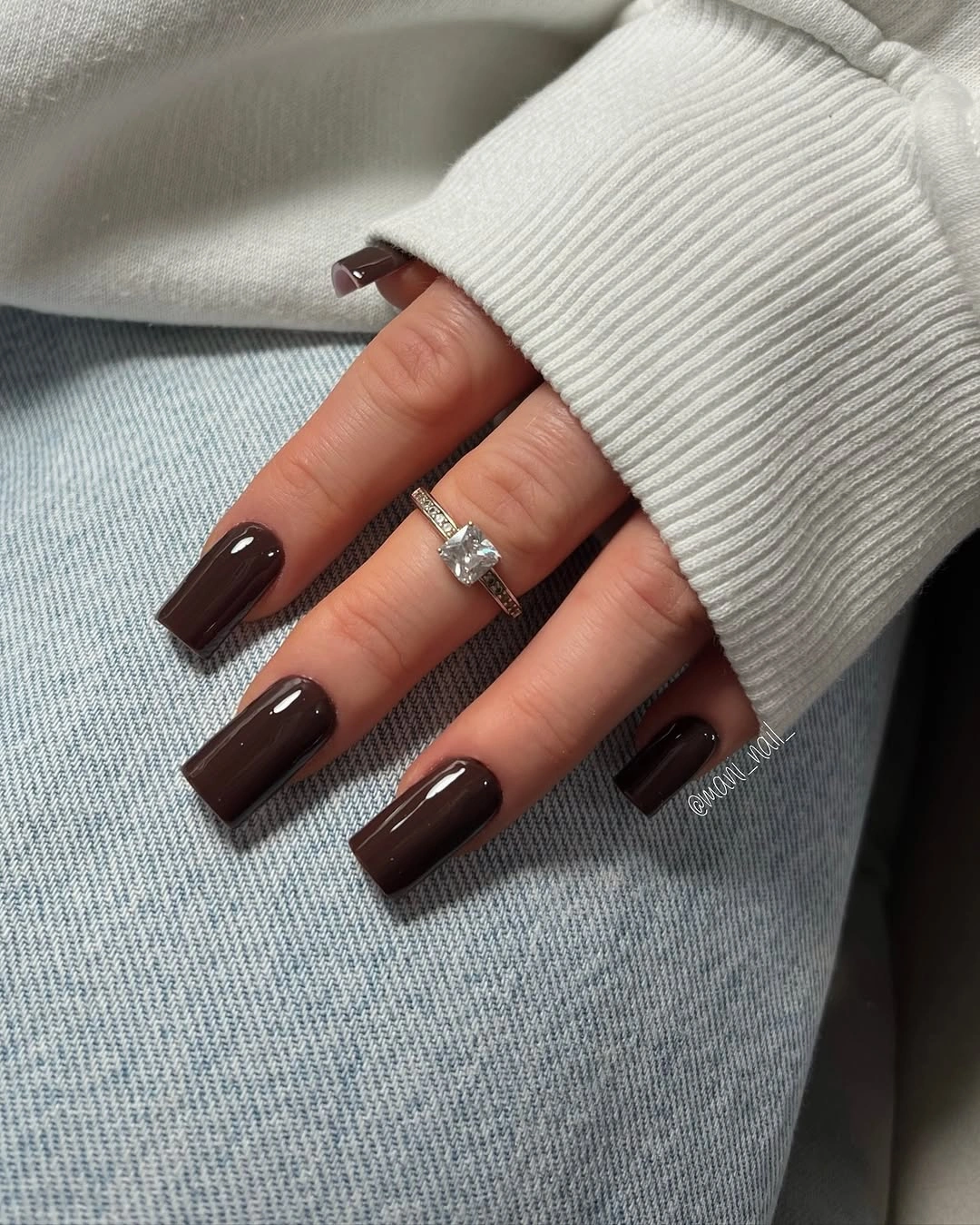 Glossy chocolate brown rounded square nails on a knit sleeve