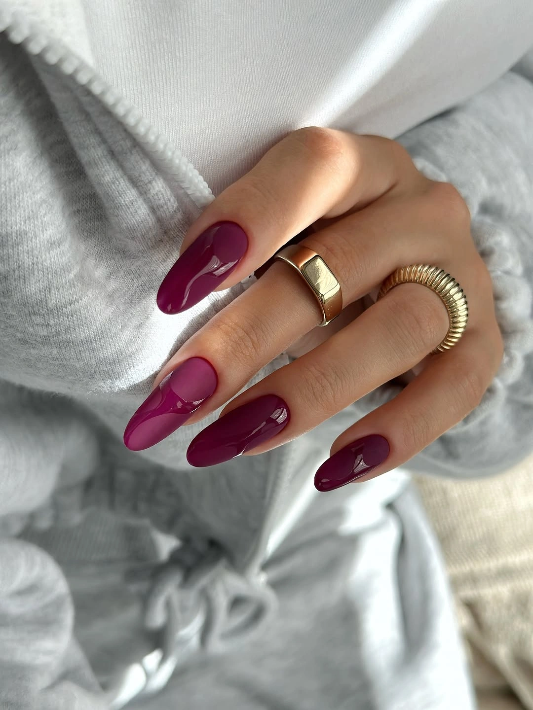 Long burgundy almond nails with subtle darker curved accents