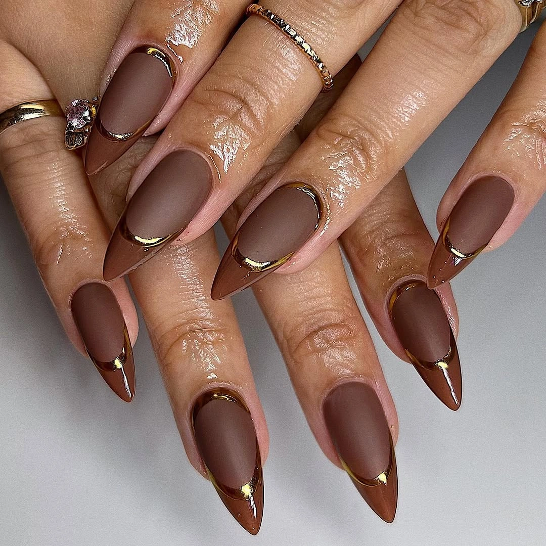 Long cocoa almond nails with nude panels and fine gold outlines