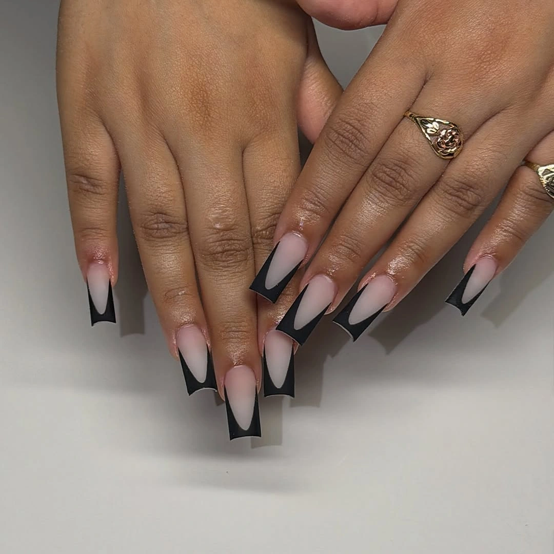 Long almond nude nails with bold black geometric French tips