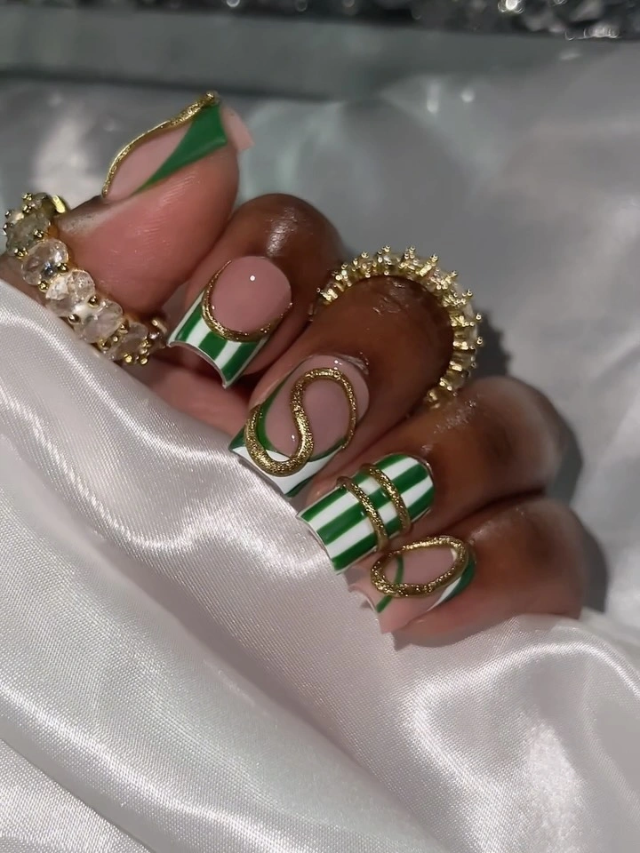 Green French blocks and stripes on nude almond nails with gold curves