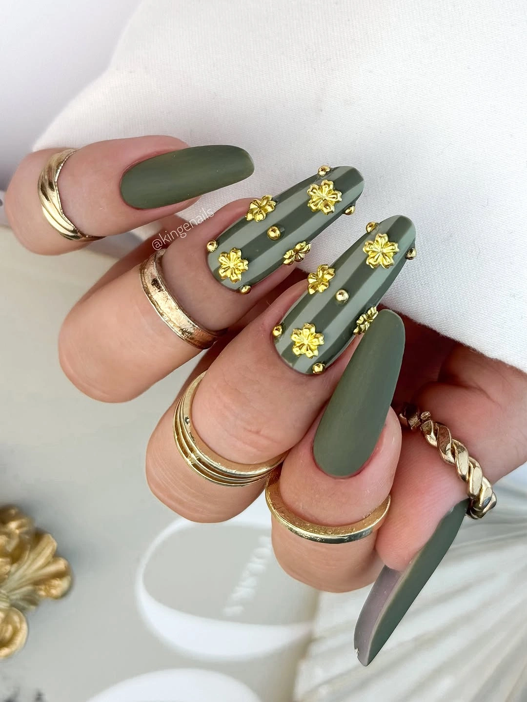 Olive almond nails with small yellow flower accents