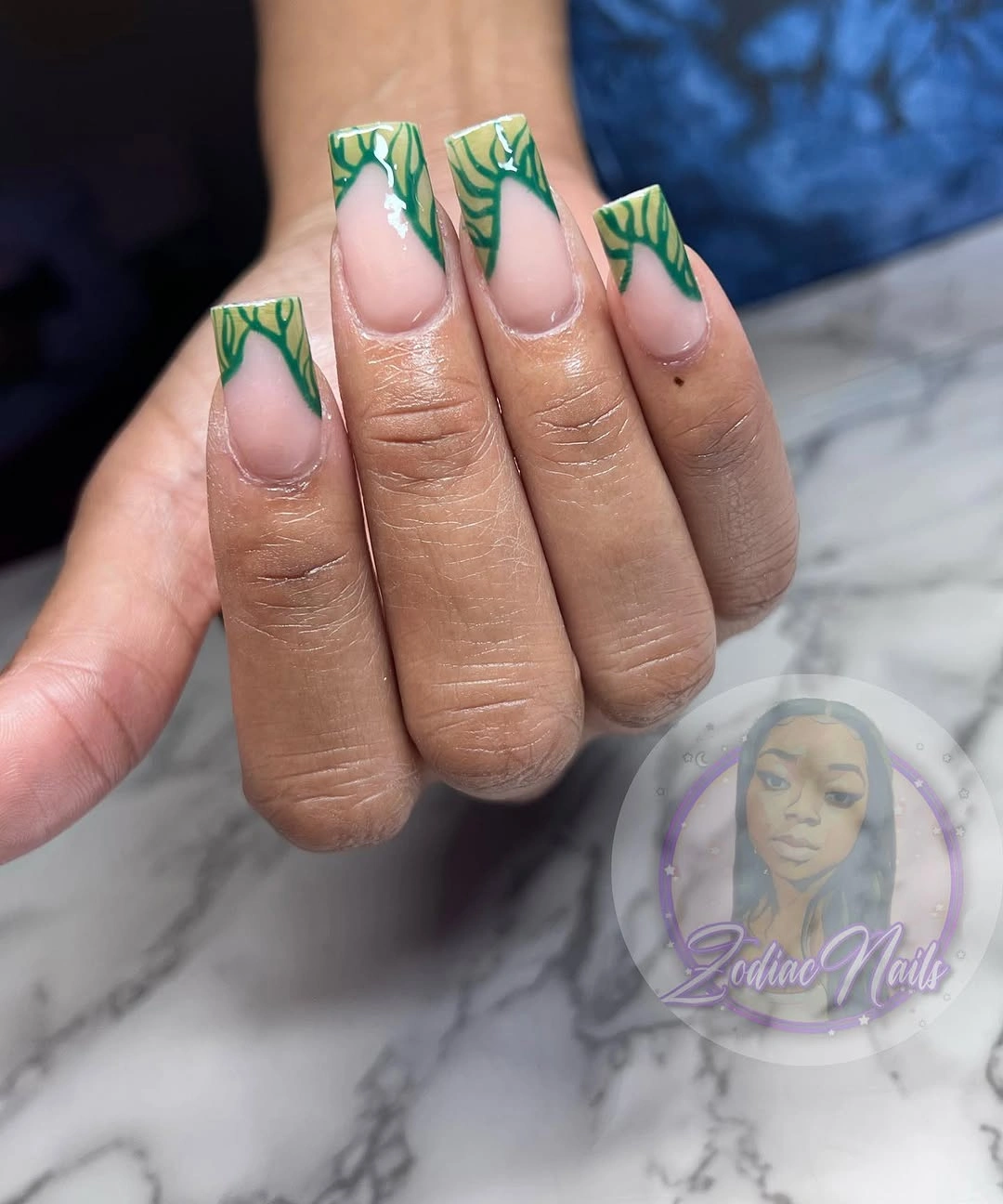 Short square nude nails with layered green leaf French tips