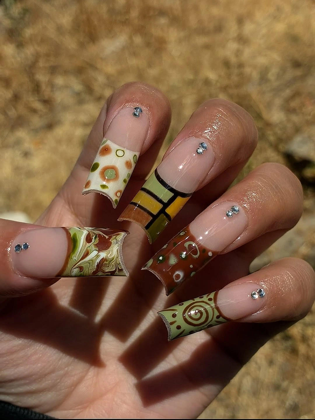 Square nails with brown mustard olive panels and small graphic accents