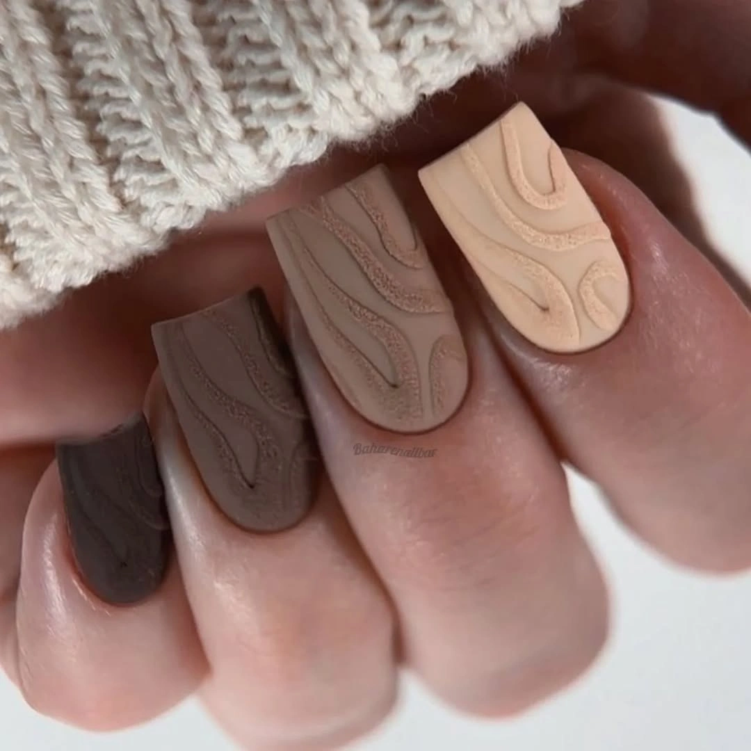 Matte neutral almond nails with raised swirl texture