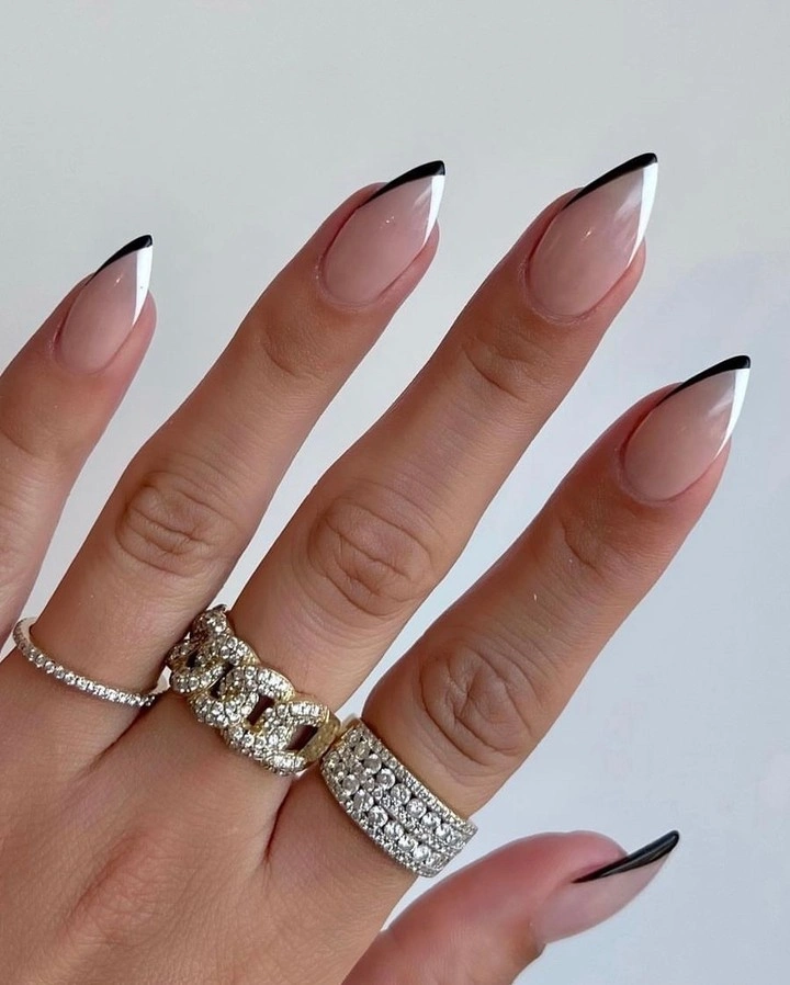 Nude almond nails with black angled French tips