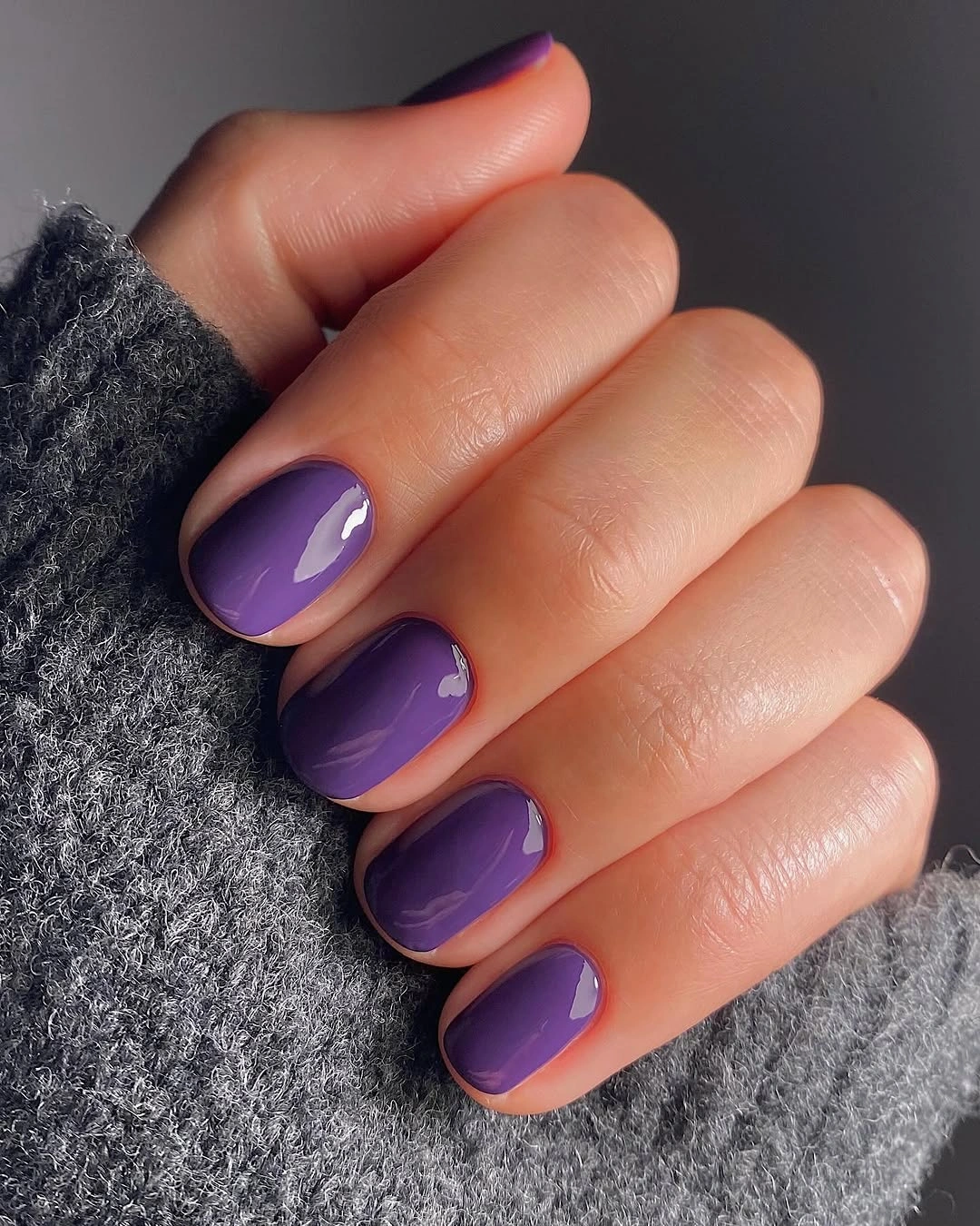 Rounded medium nails in glossy purple polish