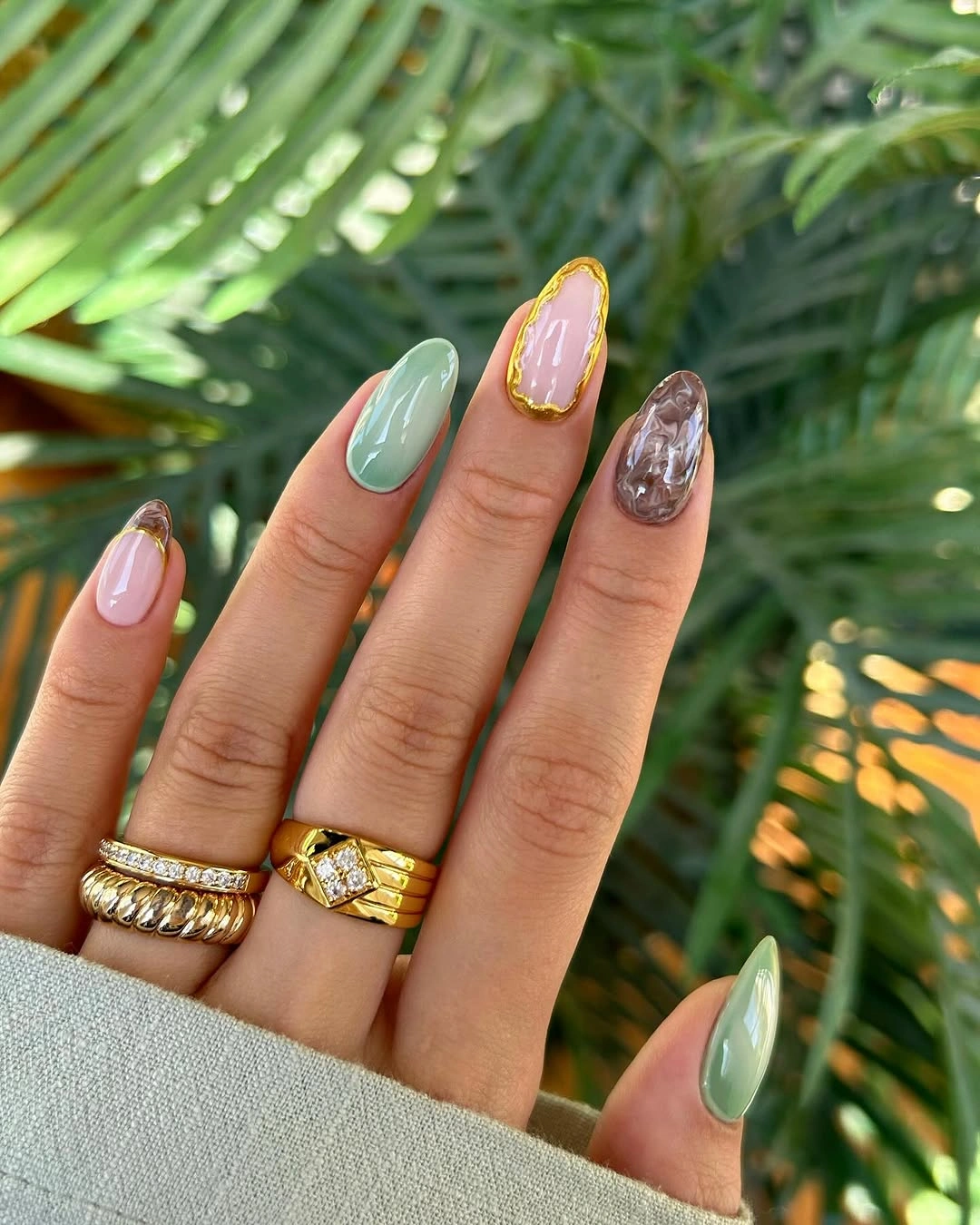 Medium almond nails with pastel green tips and reflective accents