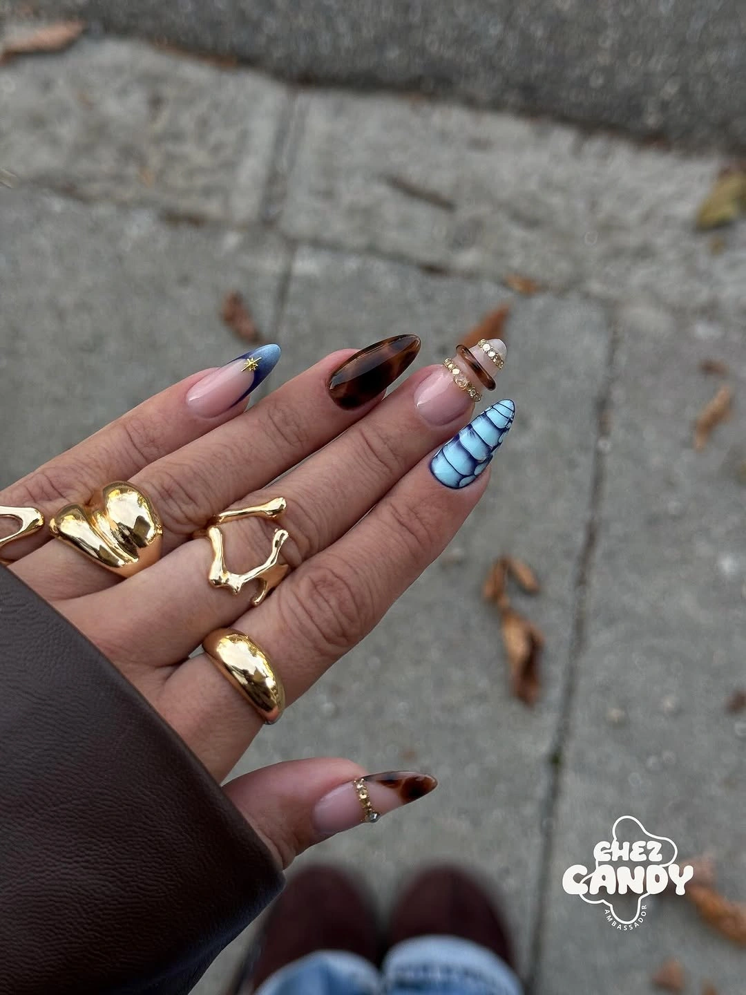 Medium square nails with earthy tips and blue striped accent