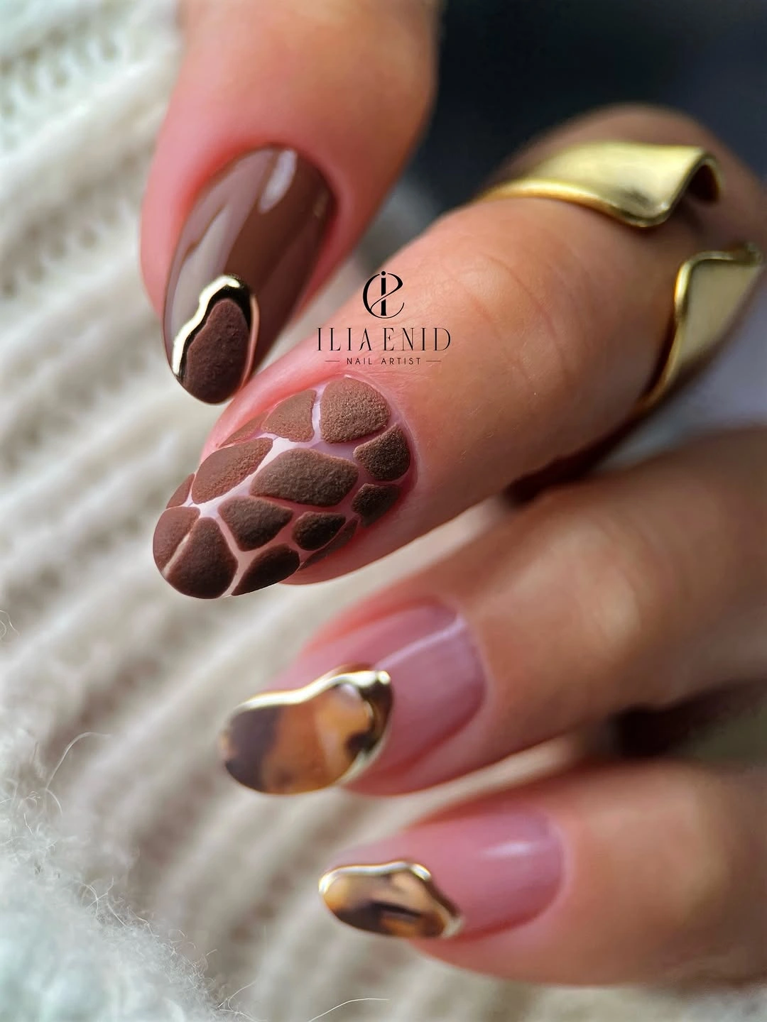 Medium almond nails with chocolate tips and one bold patterned accent
