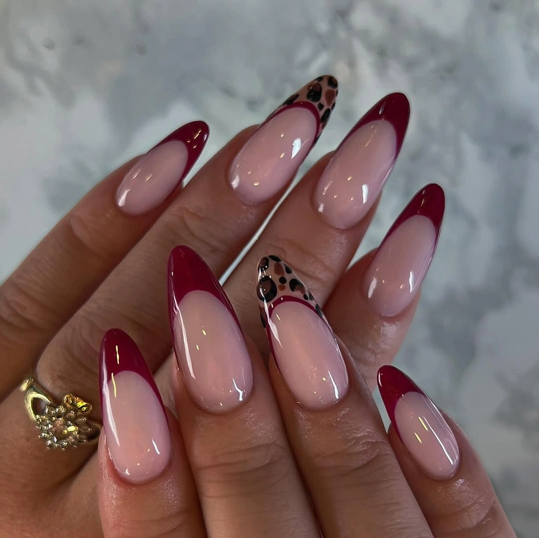 Almond nails with burgundy tips and brown patterned accents