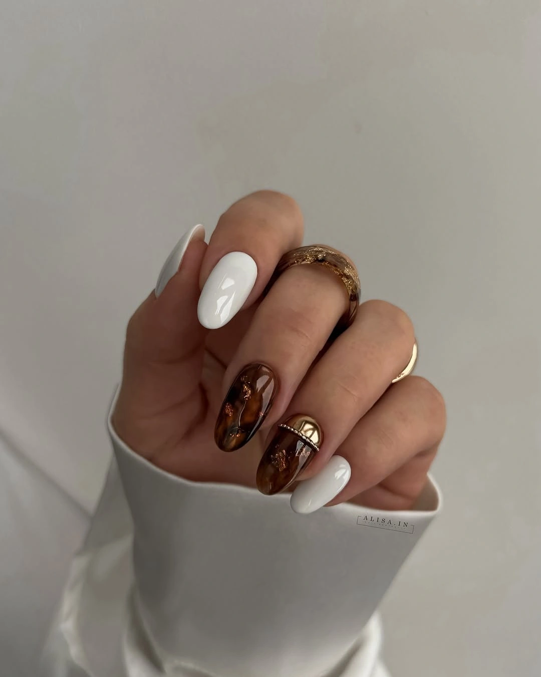 Medium almond nails with white bases and chocolate accents