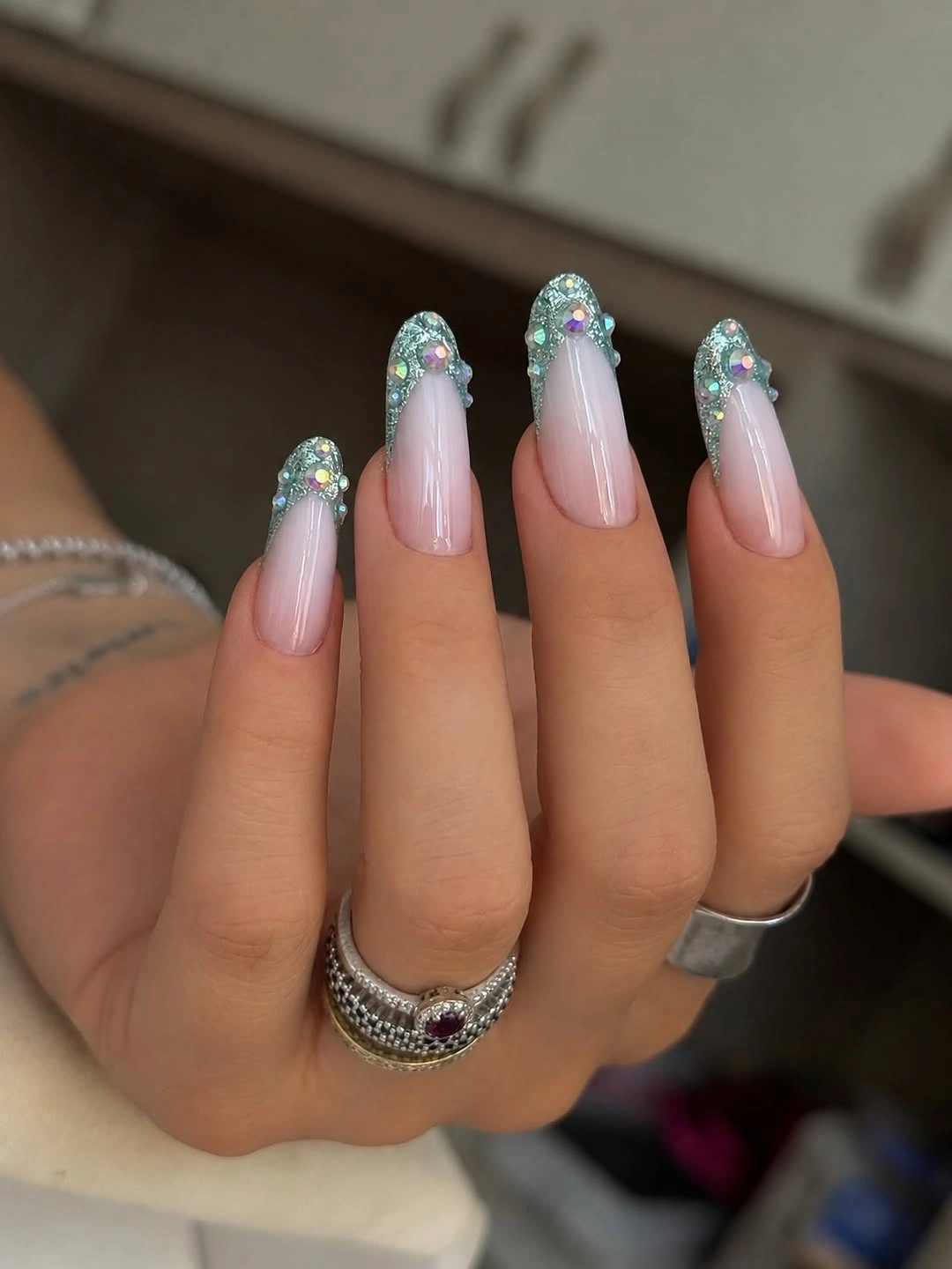 Medium almond nails with cool blue green and silver tip accents