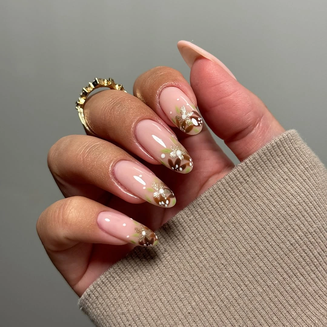 Medium almond nude nails with clustered brown orange accents