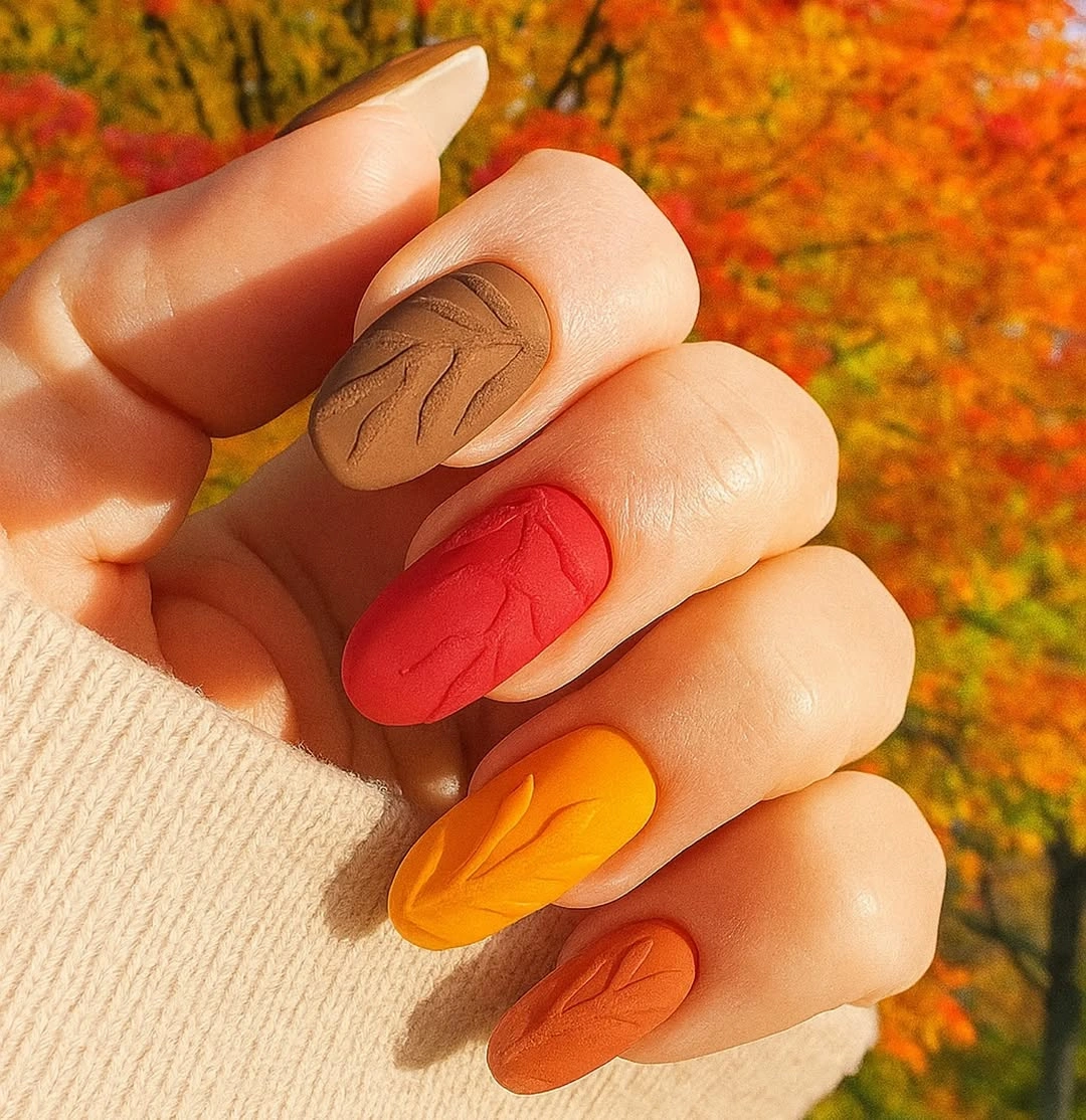 Medium almond nails in orange red yellow and brown tones