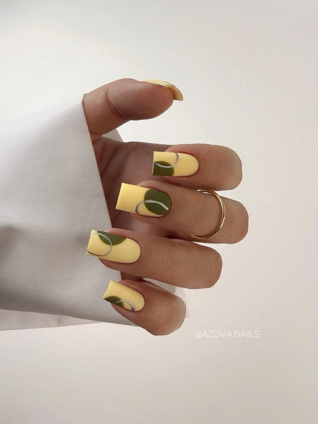 Medium almond pale yellow nails with olive loop details