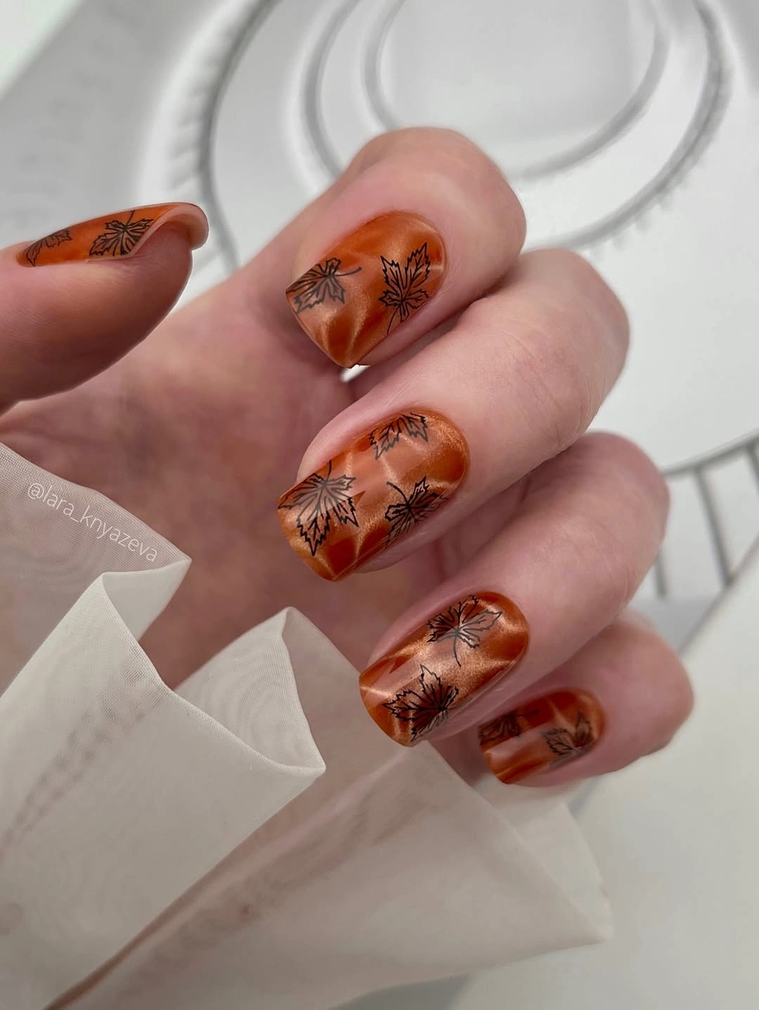 Medium almond translucent orange nails with dark botanical lines