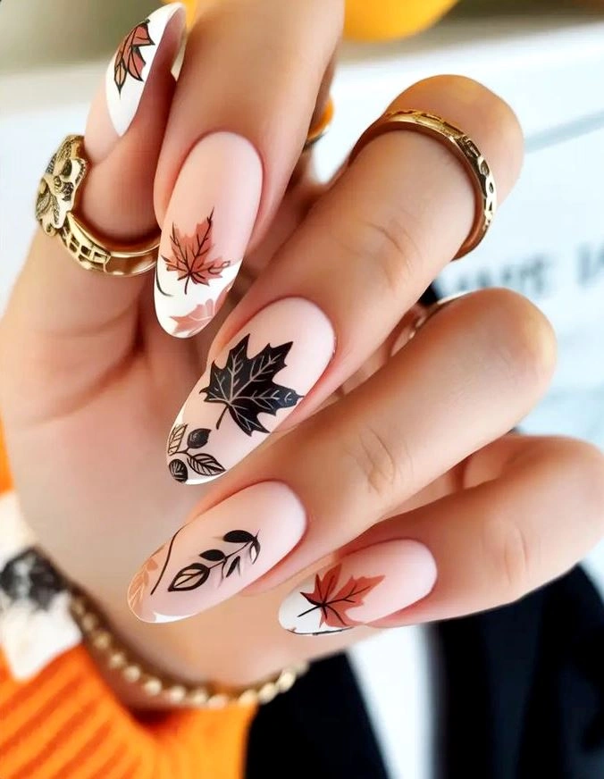 Long almond blush nails with black leaf sketches