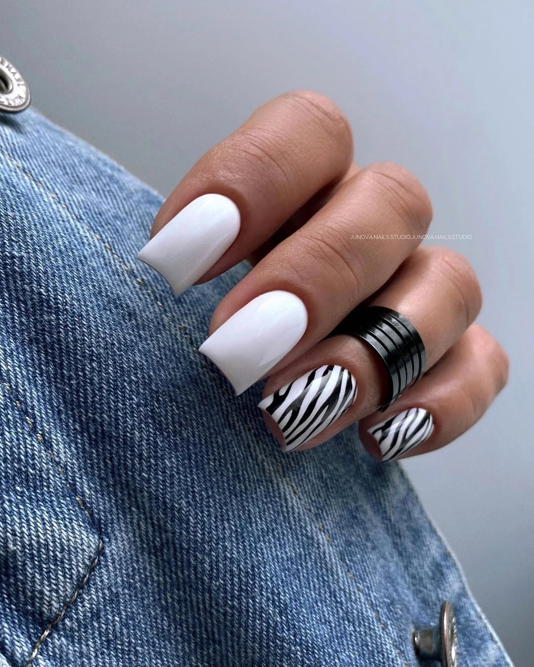 Long square white nails with one dark striped accent