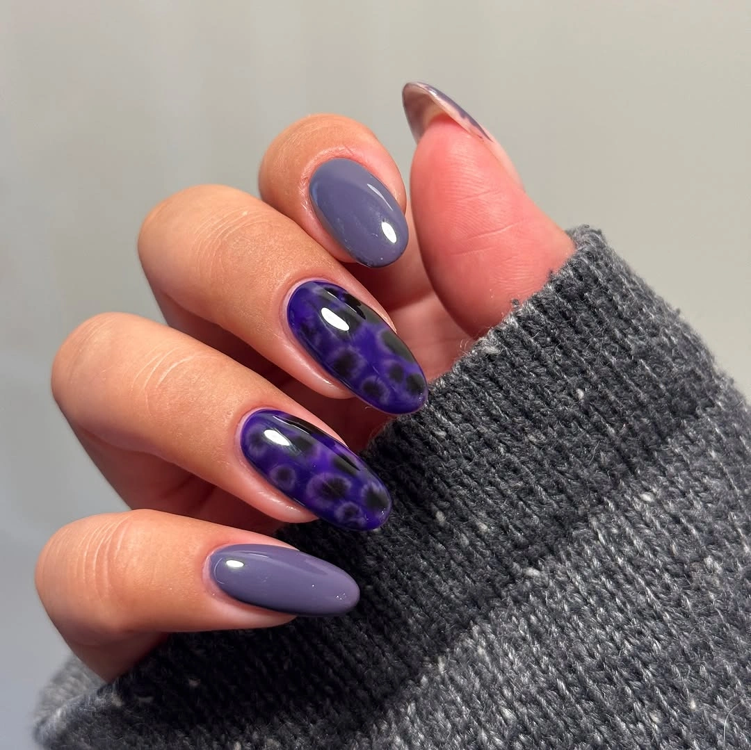 Medium almond purple nails with one dotted accent