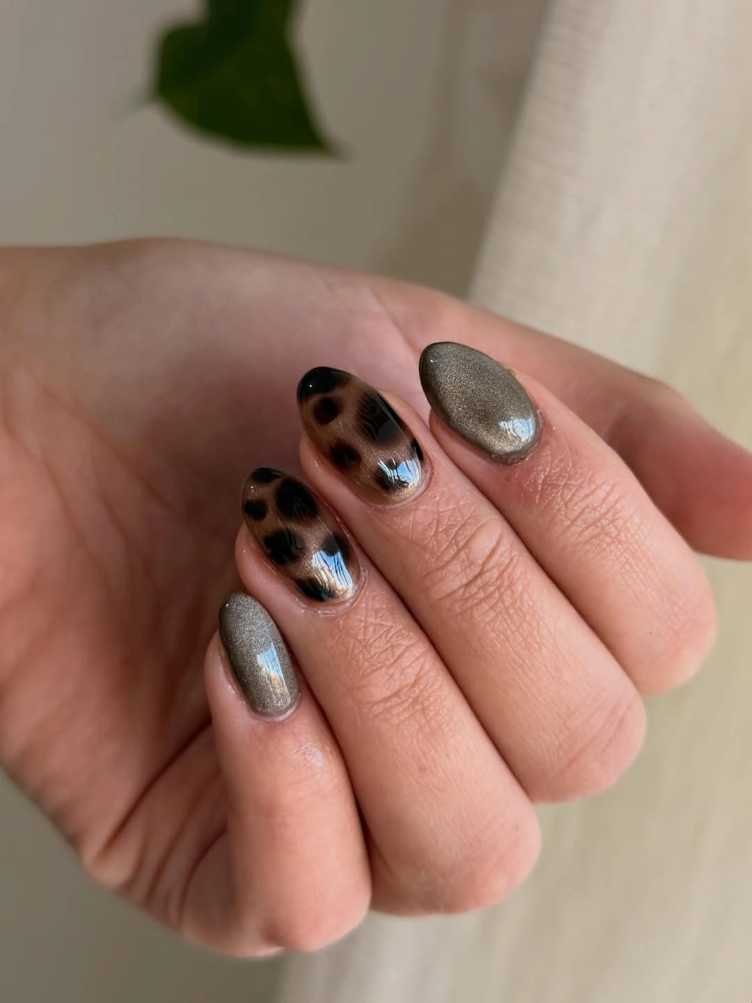 Short rounded silver nails with black spotted accents