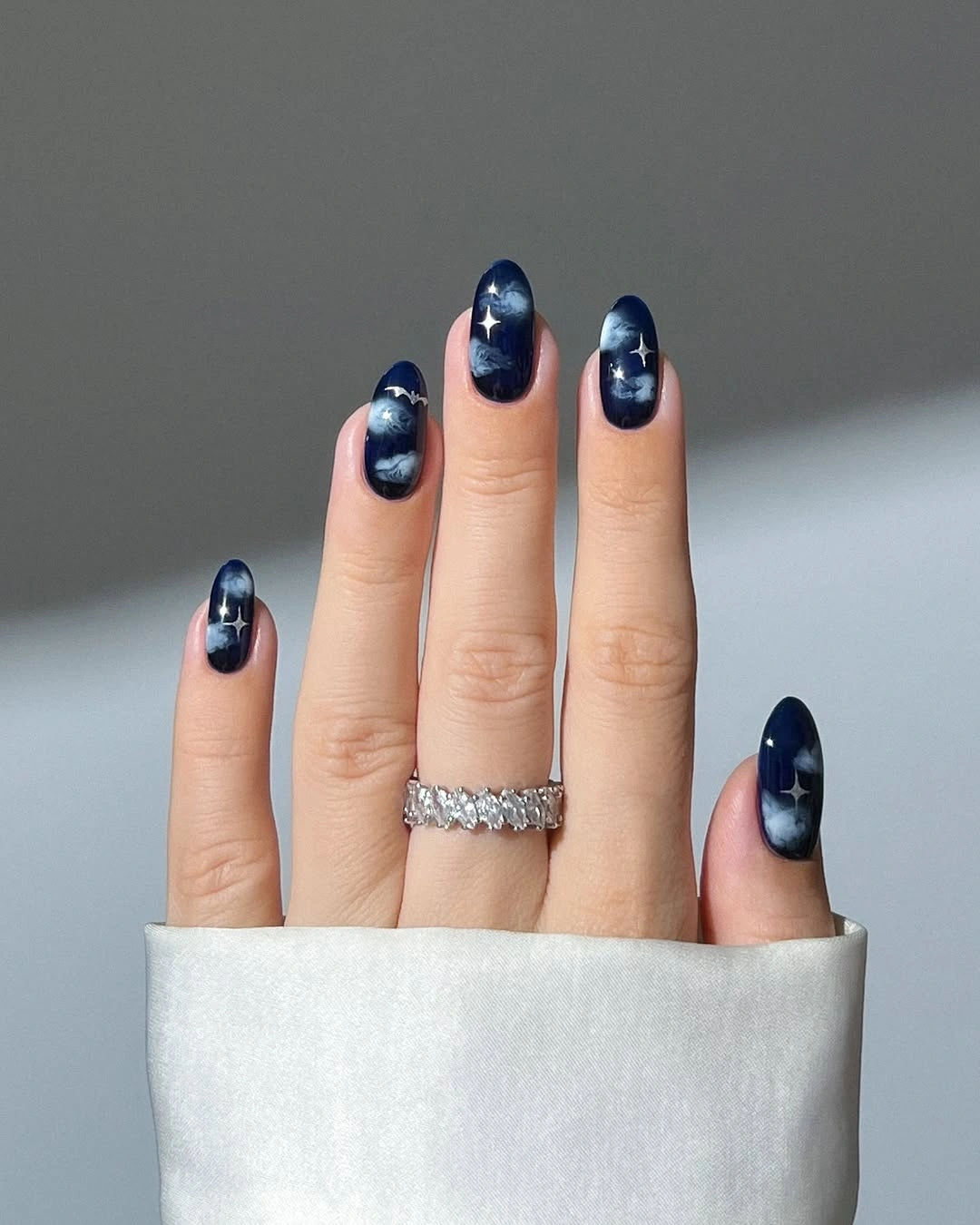 Dark navy almond nails with starry shimmer