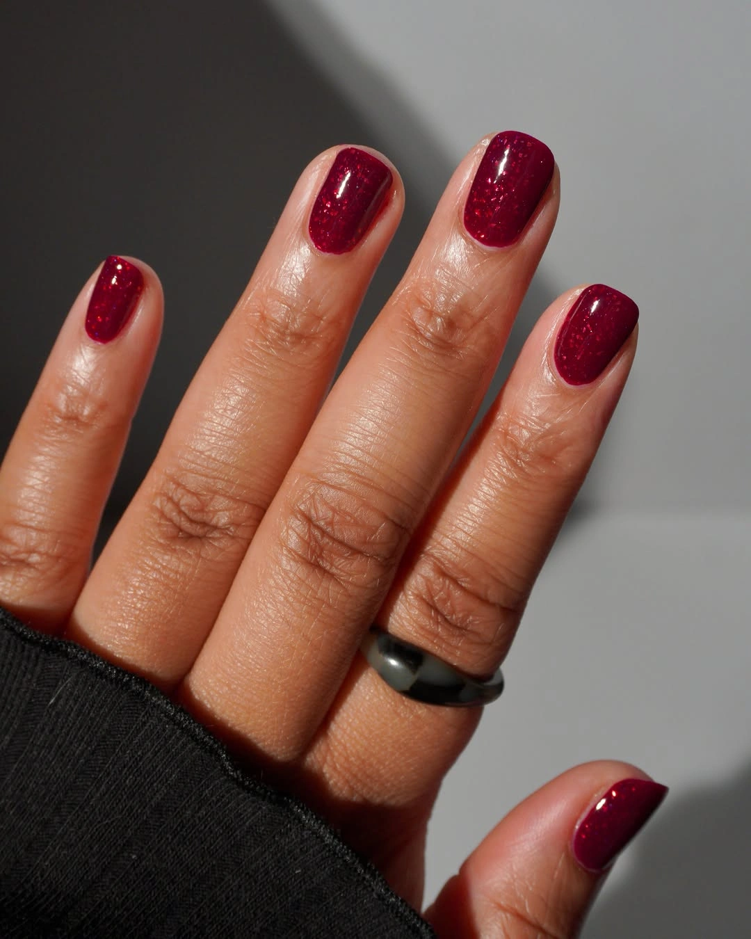 Short glossy burgundy nails on rounded shape
