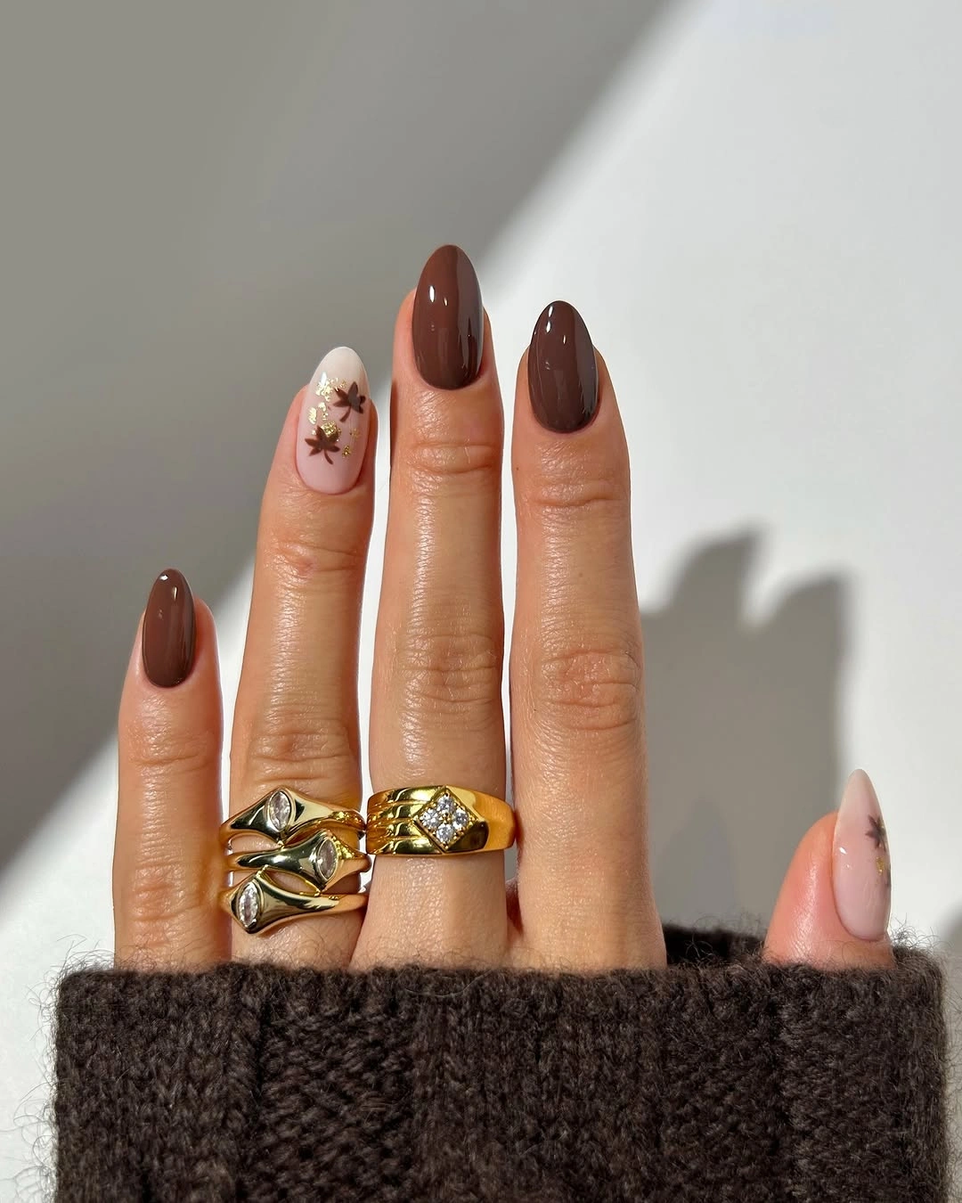 Medium almond nails with chocolate solids and one tiny accent