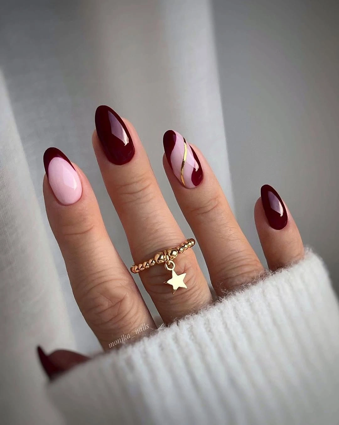 Medium almond nails with burgundy curves and pale negative space