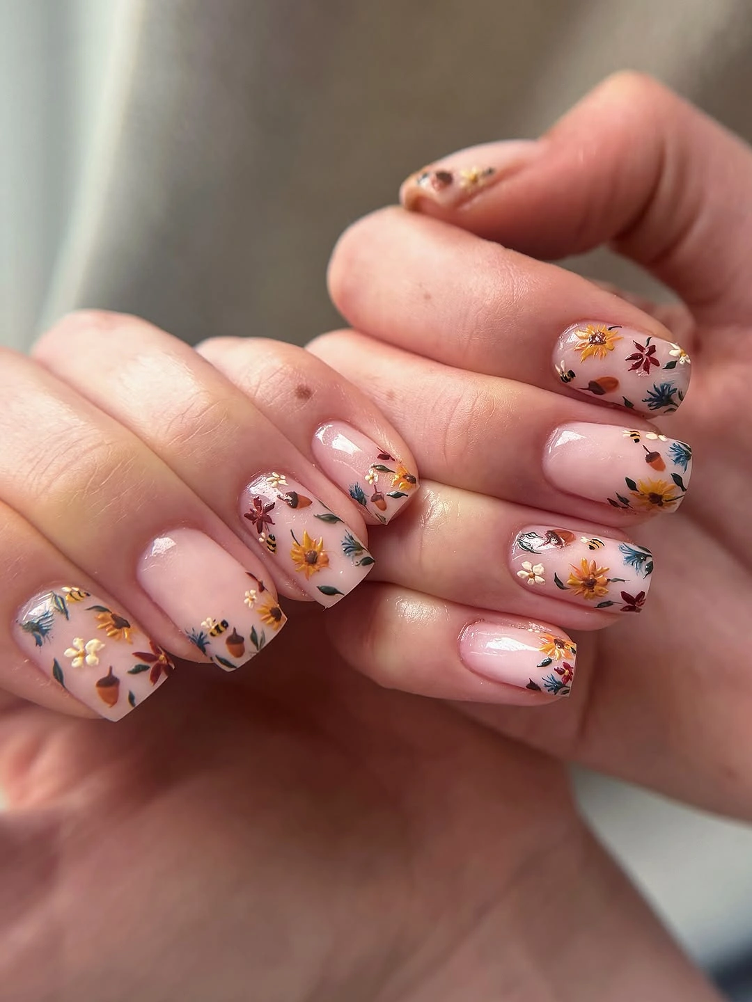 Short square pink nails with tiny multicolored floral marks