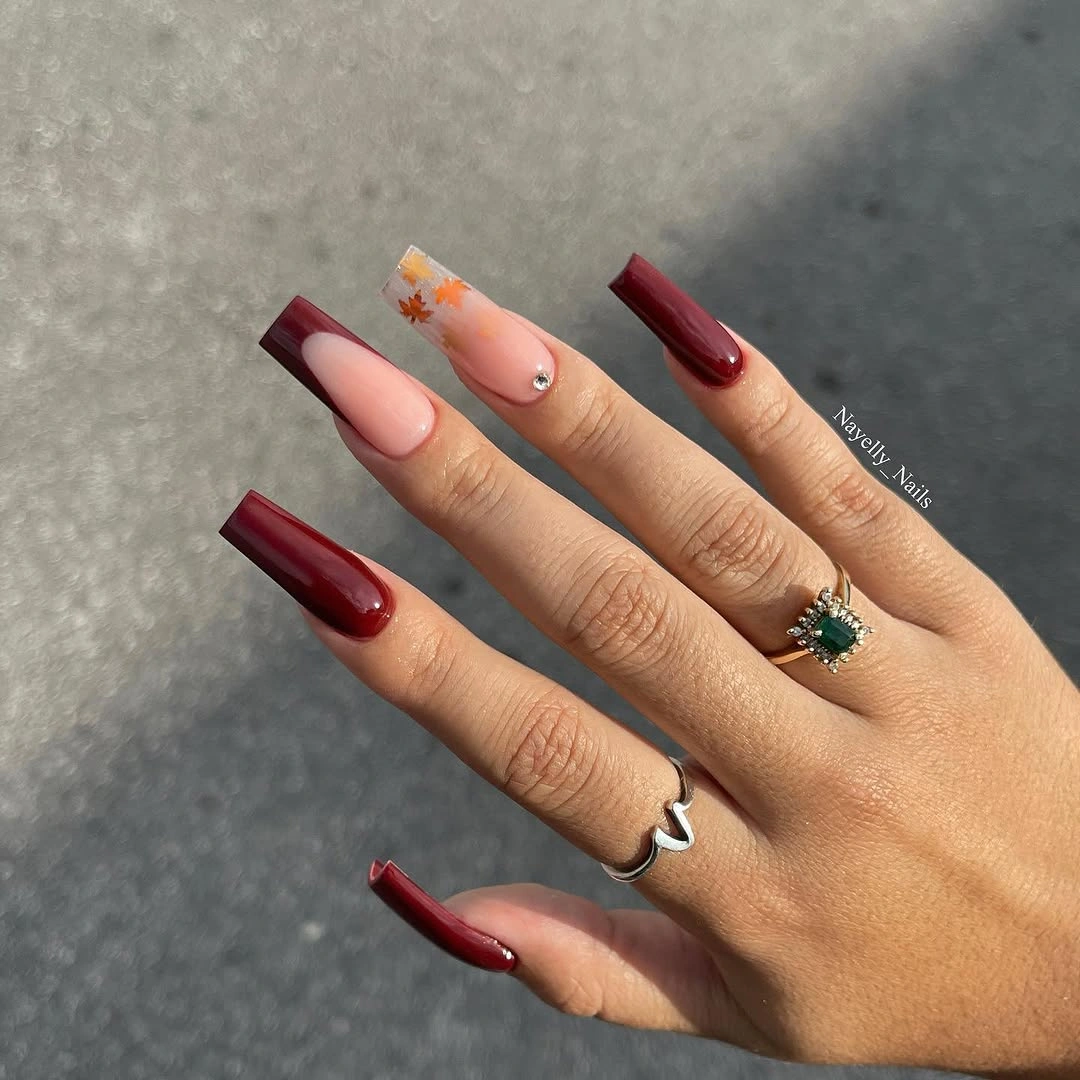 Long almond nails with burgundy tips and orange accents